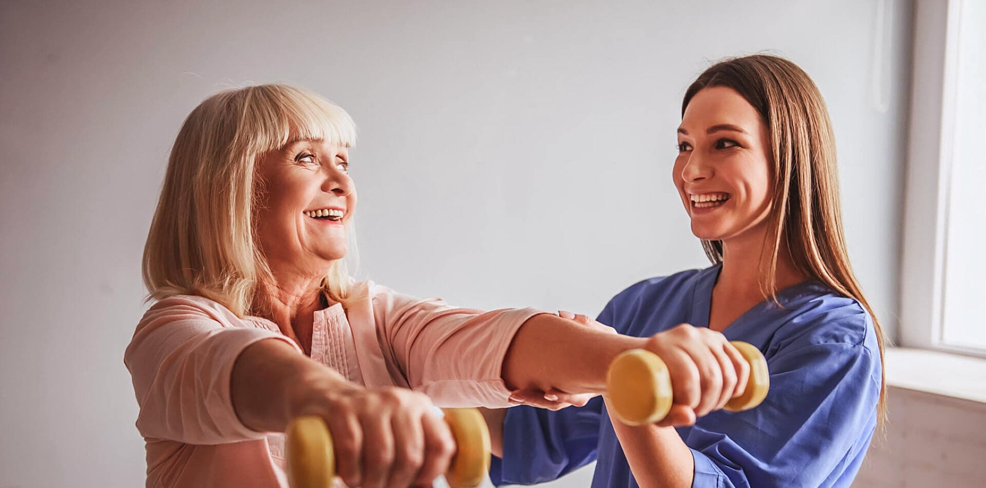 caregiver guiding senior woman to exercise
