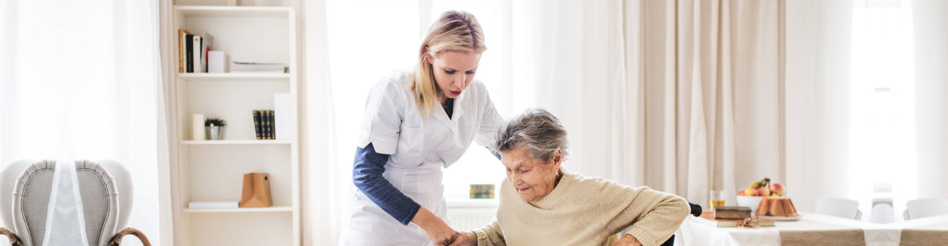 caregiver helping a senior woman to stand