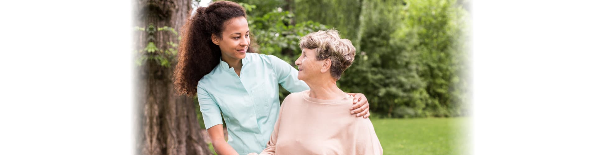 caregiver and senior woman smiling at each other